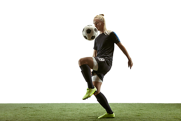 Image showing Female soccer player kicking ball at the stadium