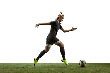 Image showing Female soccer player kicking ball at the stadium