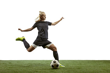 Image showing Female soccer player kicking ball at the stadium