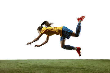 Image showing Female soccer player kicking ball at the stadium