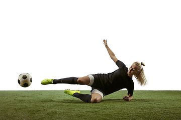 Image showing Female soccer player kicking ball at the stadium