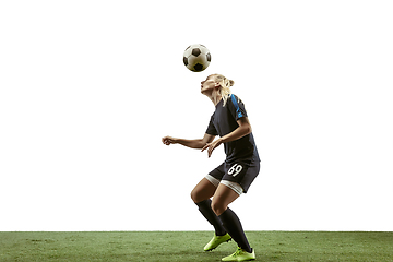 Image showing Female soccer player kicking ball at the stadium