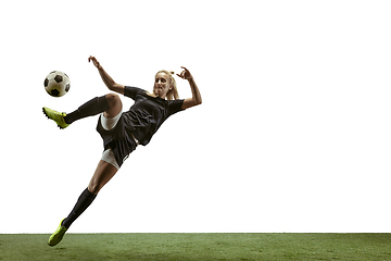 Image showing Female soccer player kicking ball at the stadium