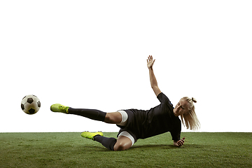 Image showing Female soccer player kicking ball at the stadium