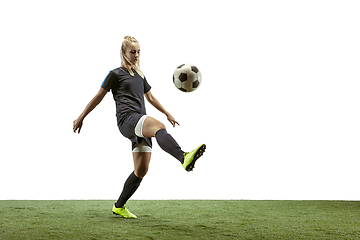 Image showing Female soccer player kicking ball at the stadium