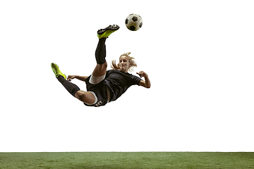 Image showing Female soccer player kicking ball at the stadium