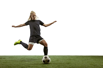 Image showing Female soccer player kicking ball at the stadium