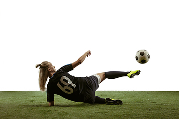 Image showing Female soccer player kicking ball at the stadium