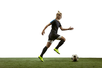 Image showing Female soccer player kicking ball at the stadium