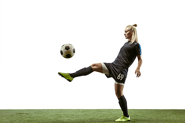 Image showing Female soccer player kicking ball at the stadium