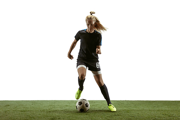 Image showing Female soccer player kicking ball at the stadium