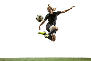 Image showing Female soccer player kicking ball at the stadium