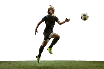 Image showing Female soccer player kicking ball at the stadium