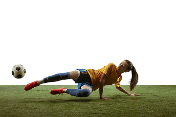 Image showing Female soccer player kicking ball at the stadium