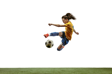 Image showing Female soccer player kicking ball at the stadium