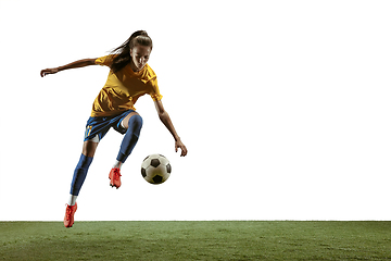 Image showing Female soccer player kicking ball at the stadium