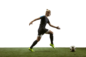 Image showing Female soccer player kicking ball at the stadium