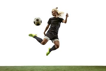 Image showing Female soccer player kicking ball at the stadium