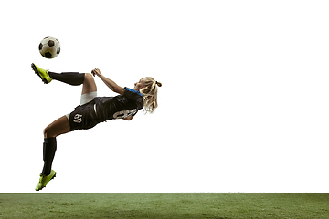 Image showing Female soccer player kicking ball at the stadium