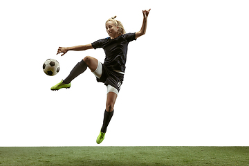 Image showing Female soccer player kicking ball at the stadium