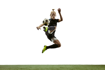 Image showing Female soccer player kicking ball at the stadium