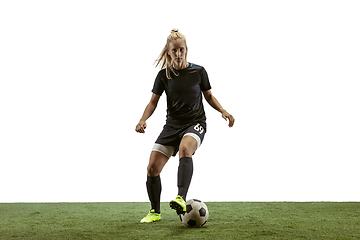 Image showing Female soccer player kicking ball at the stadium