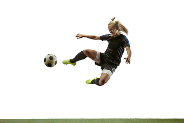 Image showing Female soccer player kicking ball at the stadium
