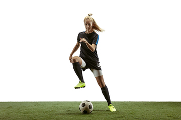 Image showing Female soccer player kicking ball at the stadium