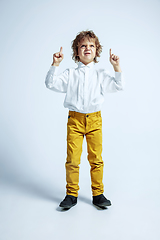 Image showing Pretty young boy in casual clothes on white studio background