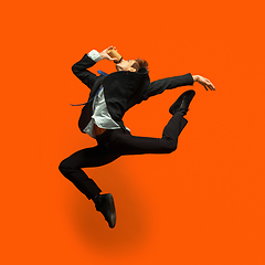 Image showing Man in casual office style clothes jumping isolated on studio background