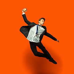 Image showing Man in casual office style clothes jumping isolated on studio background