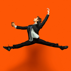 Image showing Man in casual office style clothes jumping isolated on studio background