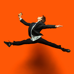 Image showing Man in casual office style clothes jumping isolated on studio background