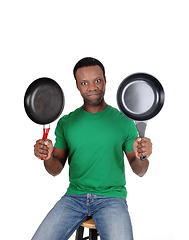 Image showing African American man holding up two freeing pan