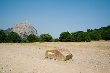 Image showing Yellow arrow on a stone, specifying a direction in mountains