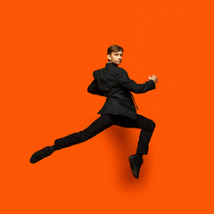 Image showing Man in casual office style clothes jumping isolated on studio background