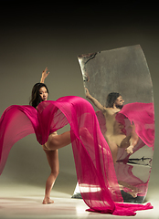 Image showing Young and stylish modern ballet dancer on brown background