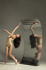 Image showing Young and stylish modern ballet dancer on brown background