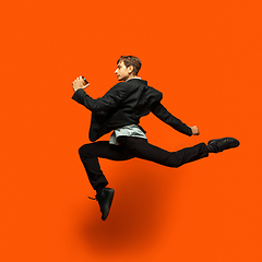 Image showing Man in casual office style clothes jumping isolated on studio background