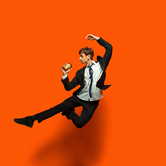 Image showing Man in casual office style clothes jumping isolated on studio background