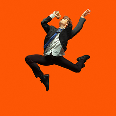 Image showing Man in casual office style clothes jumping isolated on studio background