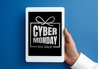 Image showing Male hand holding tablet with cyber monday words on blue background