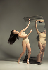 Image showing Young and stylish modern ballet dancer on brown background