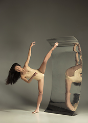 Image showing Young and stylish modern ballet dancer on brown background