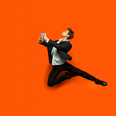 Image showing Man in casual office style clothes jumping isolated on studio background