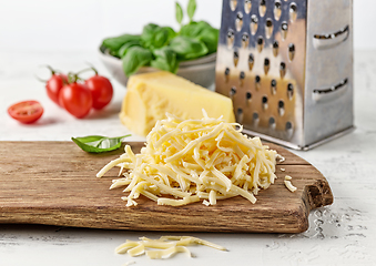 Image showing grated cheese on wooden cutting board