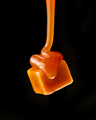 Image showing caramel sauce flowing on flying caramel candy