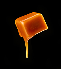 Image showing caramel sauce flowing on flying caramel candy