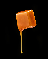 Image showing caramel sauce flowing on flying caramel candy