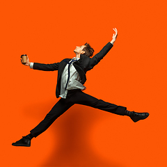 Image showing Man in casual office style clothes jumping isolated on studio background